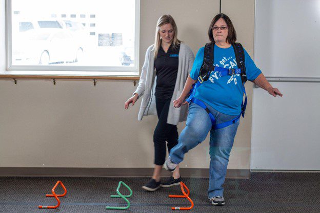 Physical therapist and patient working through a balance exercise with solo step