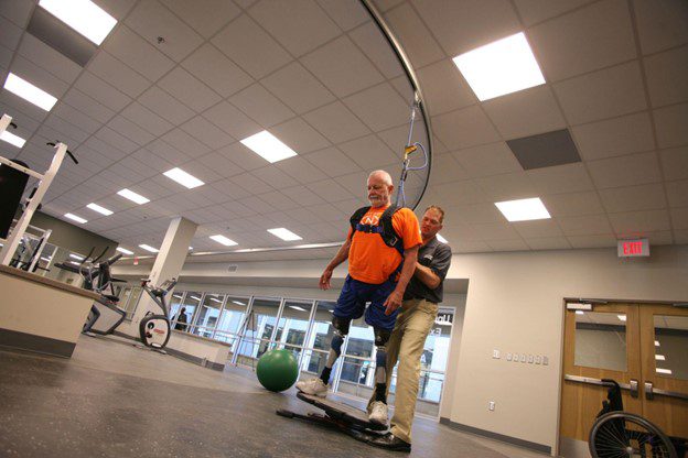 A man with prosthetic legs uses a balance board