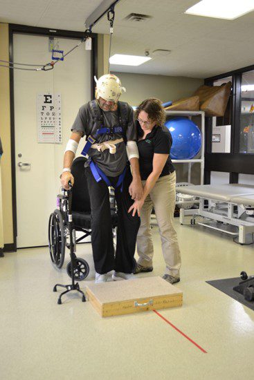 A stroke patent practices stepping over objects with the help of a physical therapist.