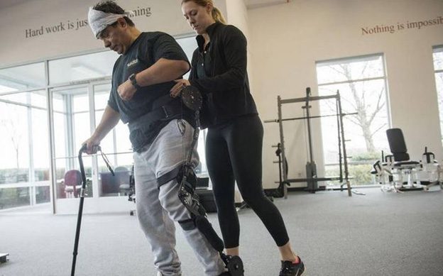 Physical therapist helping a patient walk with an ankle foot orthoses