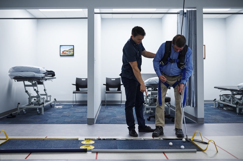 man putting golf balls while in physical therapy