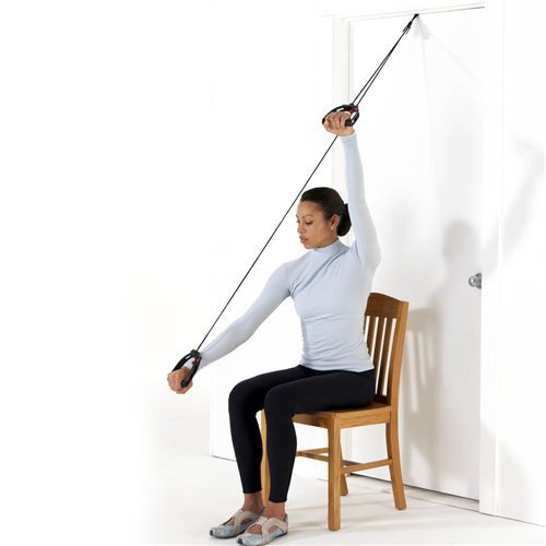 woman in chair sitting in front of door with pulley to work arms